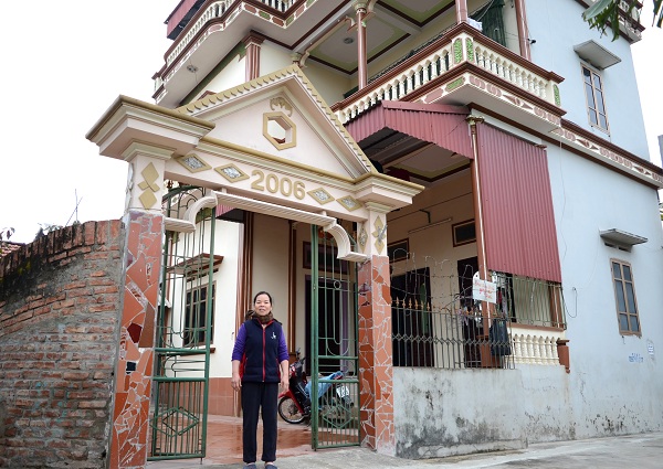 Bà Nguyễn Thị Hậu (thôn Hạc Sơn, xã Châu Sơn) bên căn nhà cao tầng từ số tiền tích cóp được khi đi xuất khẩu lao động